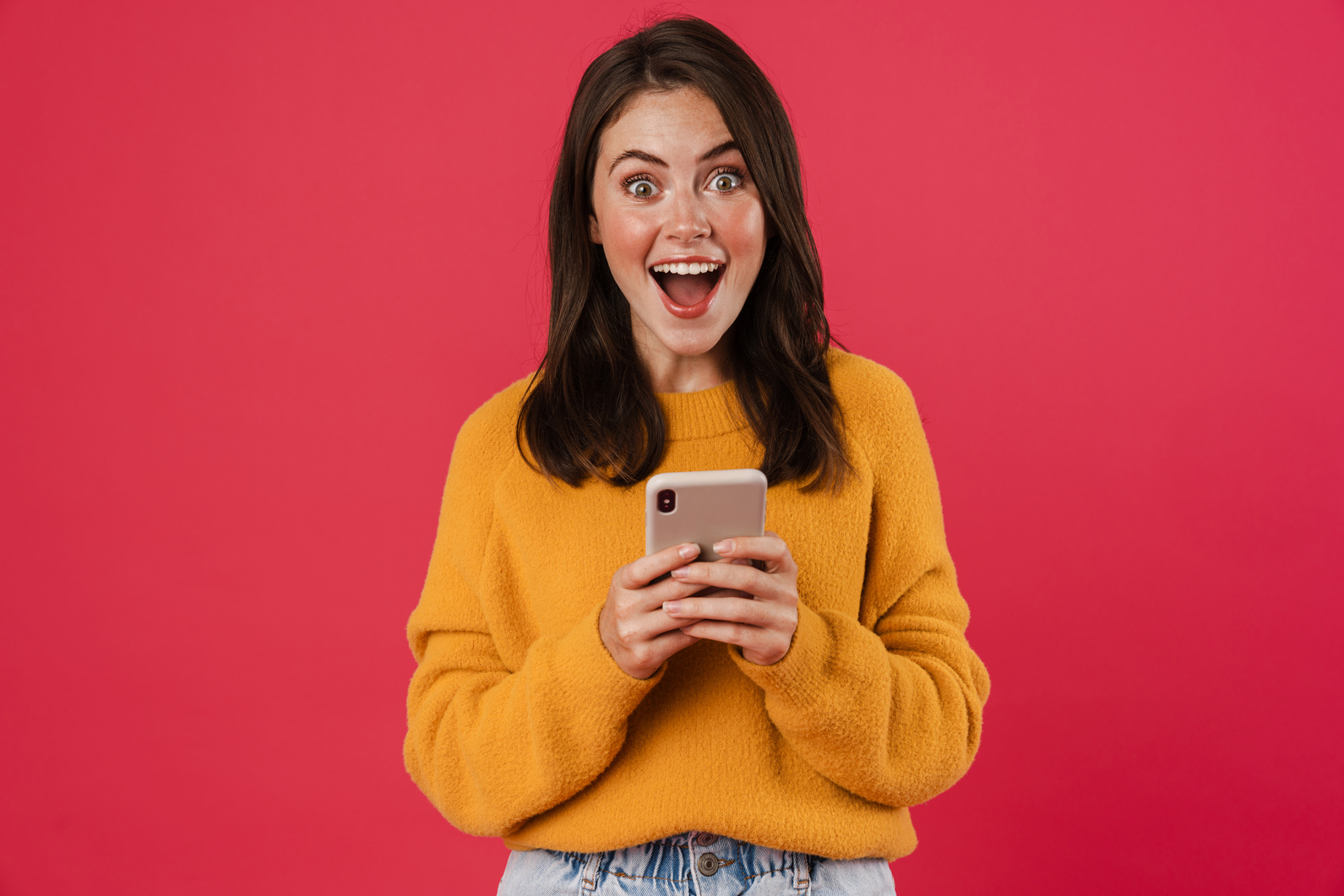 Excited Young Woman Holding Mobile Phone